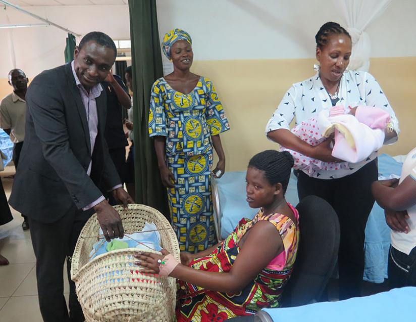 One of the beneficiaries receives a mama kit from an Airtel official. (Donah Mbabazi)