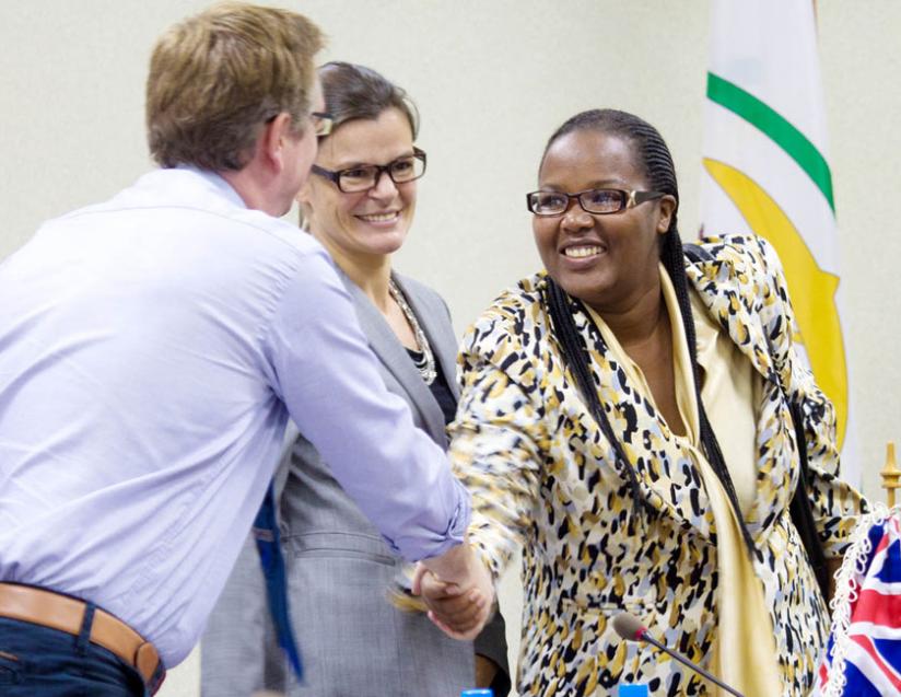 Minister Mukeshimana (R) greets Mark Davies, the DFID livelihoods advisor, as  Beaufils looks on before the signing ceremony in Kigali yesterday. (Timothy Kisambira)