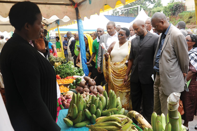 Kayonga (second, right) inspects horticulture products during the expo. (Peterson Tumwebaze)