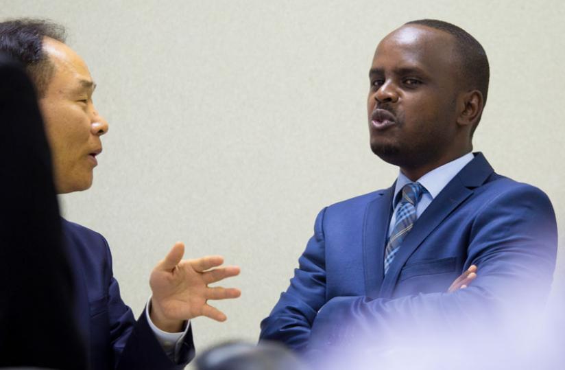 Nsanganira (R) chats with Amb. Soon-taik before the signing ceremony yesterday.(Timothy Kisambira)