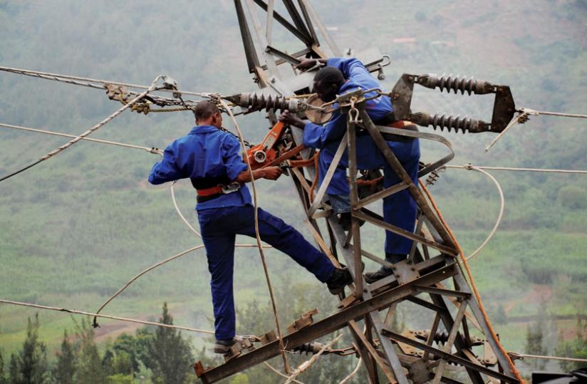 Workers fix a power line. Rwanda has signed an agreement to buy electricity from Kenya.