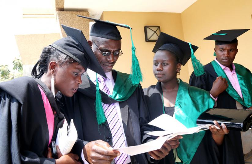 Some of the graduands look up their names on the graduation list before the ceremony. (John Mbanda)