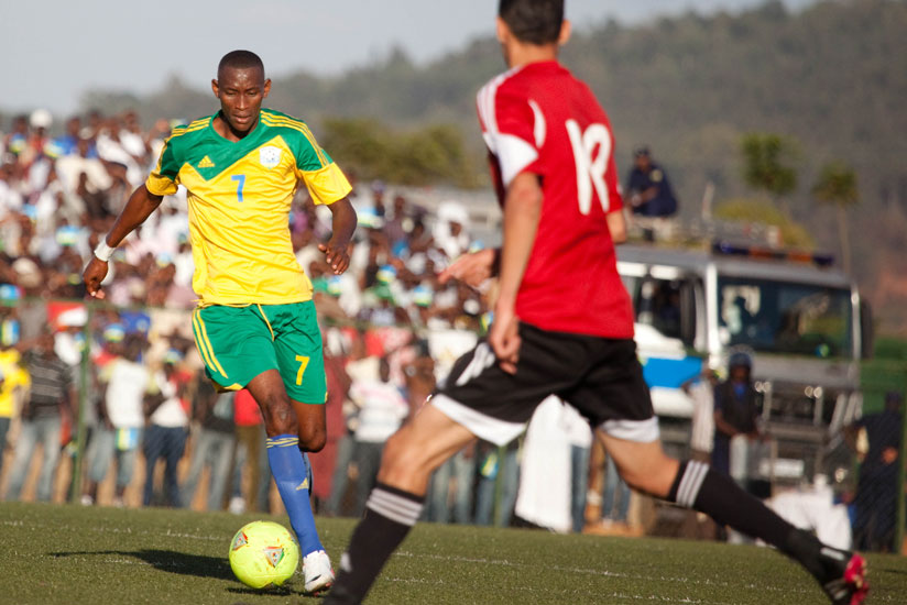 Amavubi midfielder Jean-Baptiste Mugiraneza takes on a Libyan defender in the 2015 Afcon qualifier which Rwanda won 3-0. Rwanda has attained their best ever Fifa ranking jumping from 90th position to 68th. (File photo)