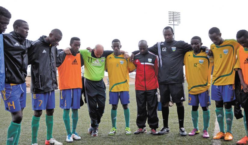 Rwanda U-23 players with Head Coach Stephen Constantine pray after Thursday's training session. Athough it is a friendly game,Constantine is keen to win. (Sam Ngendahimana)