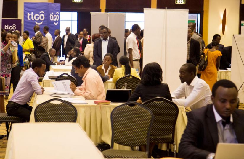 Job seekers present their credentials to potential employers' representatives at the Rwanda Job Day fair in Kigali yesterday. (Timothy Kisambira)