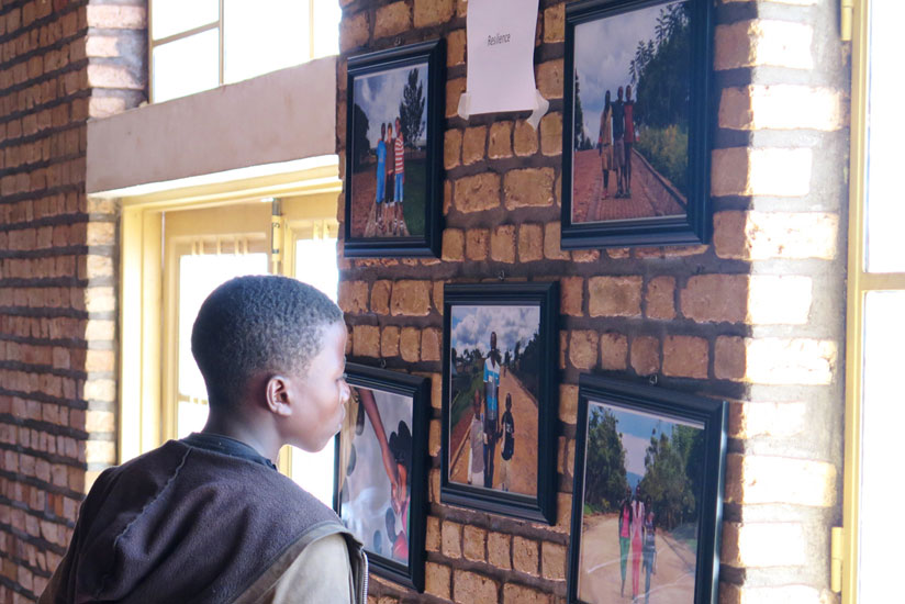 A boy admires some of the photos. The exhibition aimed at encouraging efforts to build peace and unity. (JP Bucyensenge)