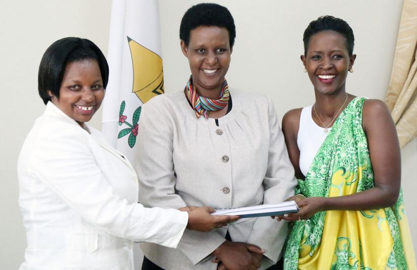 Outgoing executive secretary Christine Tuyisenge (L) hands over to Jacqueline Kamanzi as Gender Minister Oda Gasinzigwa (C) looks on. (John Mbanda)