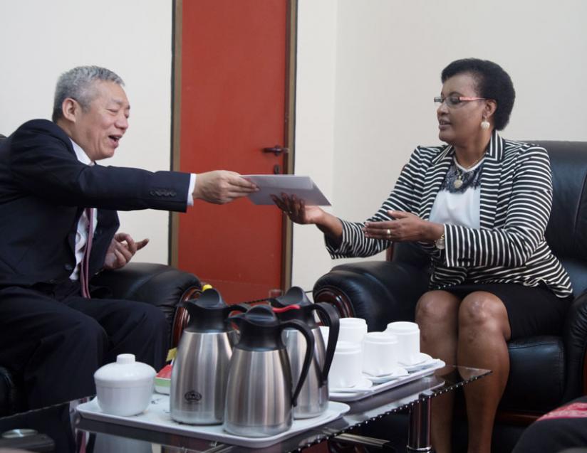 Ambassador of People's Republic of China to Rwanda Shen Yongxiang( L) gives a parcel containing Merry Christmas message  to Speaker of Parliament Mukabalisa Donatille