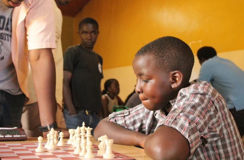 A young boy playing chess in a tournament early this year. Many children embraced the game this year. (F. Mugisha)