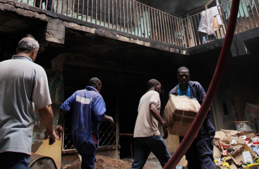 Rescuers carry merchandise from a burning building in Muhima in September last year. (File)