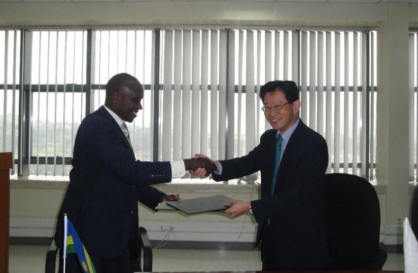 Ruzigana receives documents from Amb. Ogawa on Wednesday. (Timothy Kisambira)