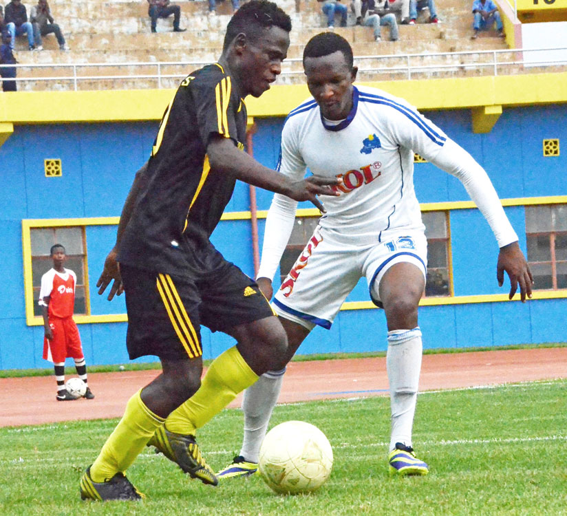 Rayon Sports defender James Tubane (R) blocks a Mukura striker during yesterday's goalless draw.  (Sam Ngendahimana)