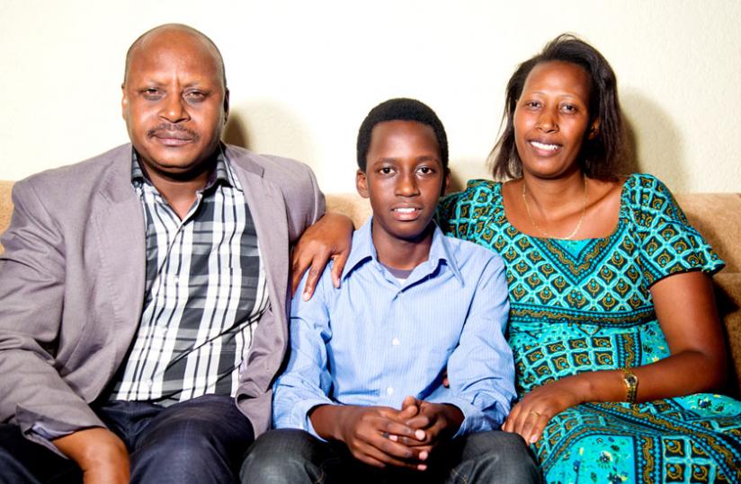 O-Level best student James Ishimwe with his parents at their home. (Timothy Kisambira)