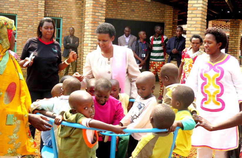 Minister Gasinzigwa (centre) and Uwamariya (right) interact with children during the inauguration of the children centre in Zaza Sector, Ngoma District on Wednesday . (Stephen Rwembeho)