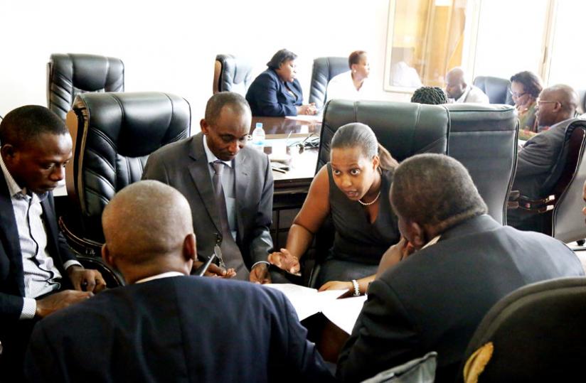 PS Sayinzoga (2R), Seminega (C) and other staff from the Finance ministry, consult in Parliament yesterday. (John Mbanda)