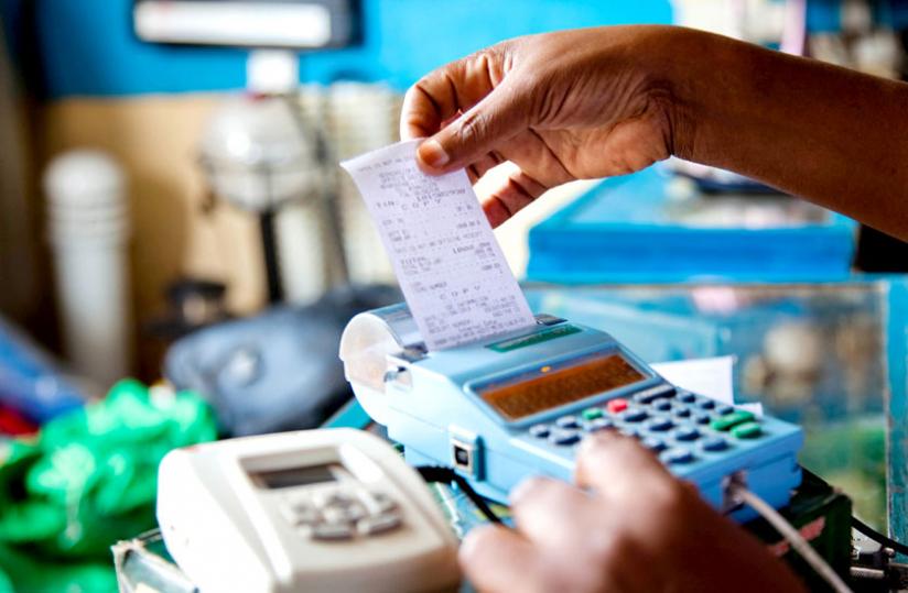 A trader retrievesa receipt from an EBM. The amended law reinforces ministerial powers to fine taxpayers who circumvent using electronic billing machines to avoid paying taxes. (File)