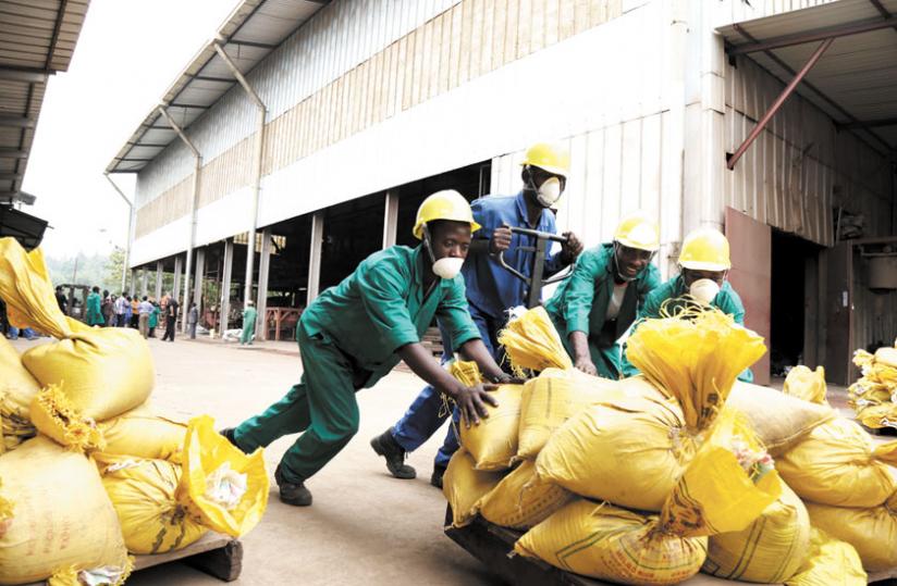 Workers at Phoenix Metals Ltd push bags of minerals after weighing them at the plant yesterday. (John Mbanda)