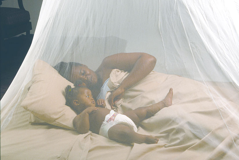A mother and her child tucked under a bed net. Fighting malaria takes more than just a good net and encompasses proper usage. (File)