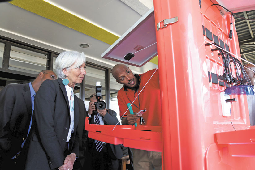 IMF Director General, Christine Lagarde (L) looks at a solar charger at kLab yesterday. (John Mbanda)