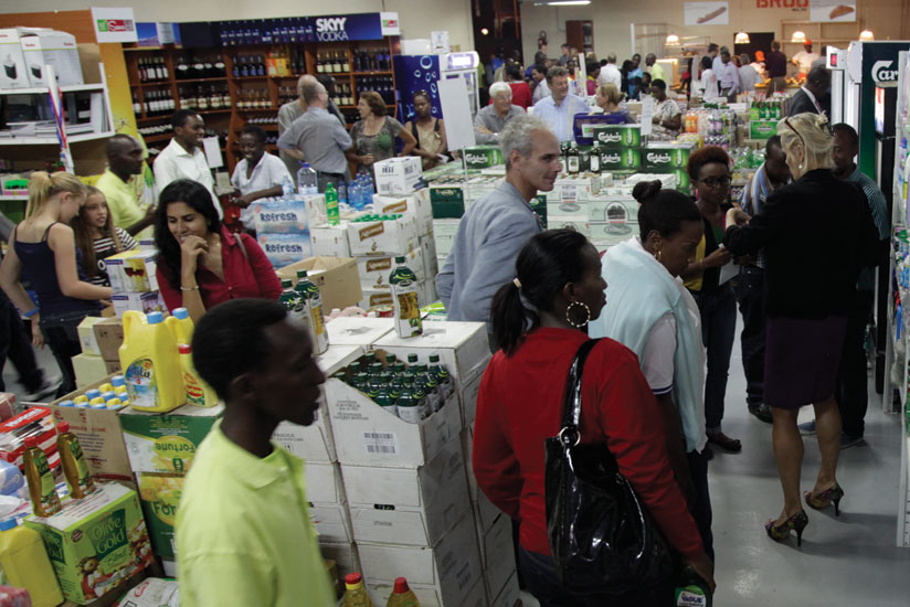 An attendant (left) watches as buyers check out items at a city supermarket. Clients are key in improving customer service.