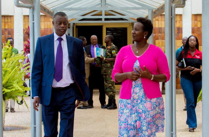 Kabarebe (L) chats with Juliene Uwacu, the deputy chairperson of Standing Committee on Foreign Affairs, Cooperation and Security as they leave Parliament yesterday. (Timothy Kisambira)