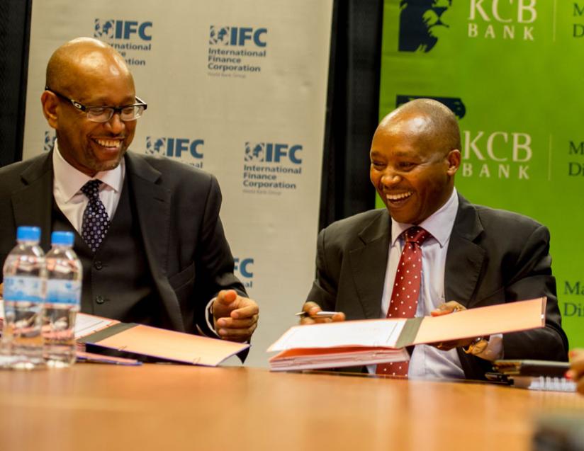Rwanda's Managing Directors of KCB Maurice Toroitich(R) s hare a light moment with Ethiopis Tafara, IFC vice president for corporate risk and sustainability. (T.Kisambira)
