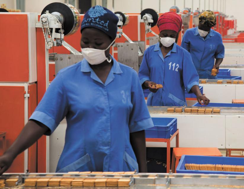 Workers package biscuits at Mount Meru Soyco. The firm makes edible oil and  biscuits from soya beans. (Timothy Kisambira)