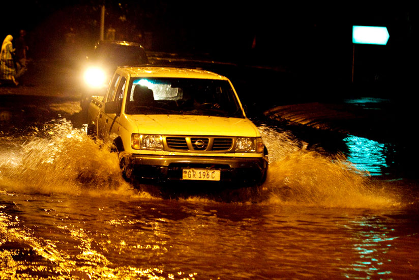 A motorist drives through a flooded street in downtown Kigali after the weekend downpour. (Timothy Kisambira)