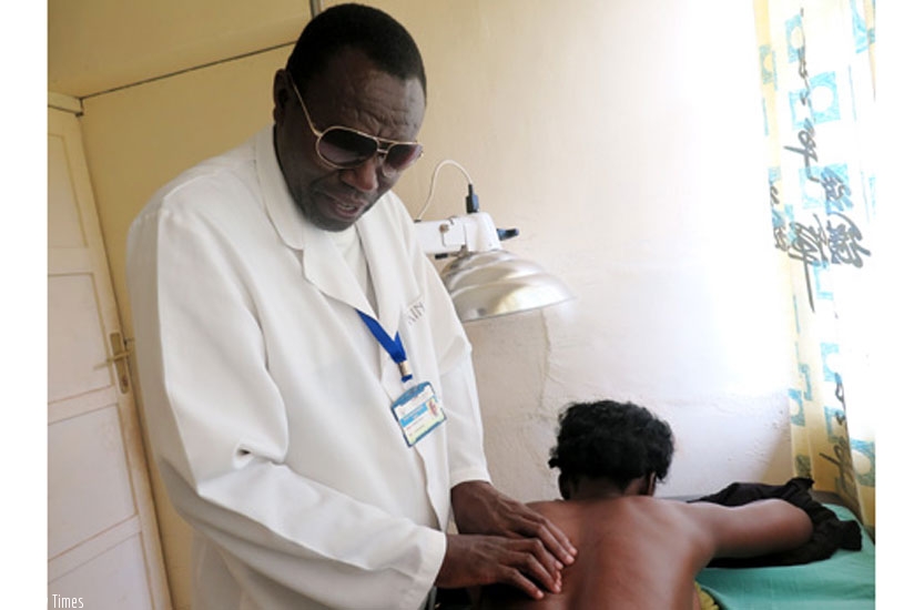 Sindabye treats a patient with backache at Nyanza Hospital. (Emmanuel Ntirenganya)