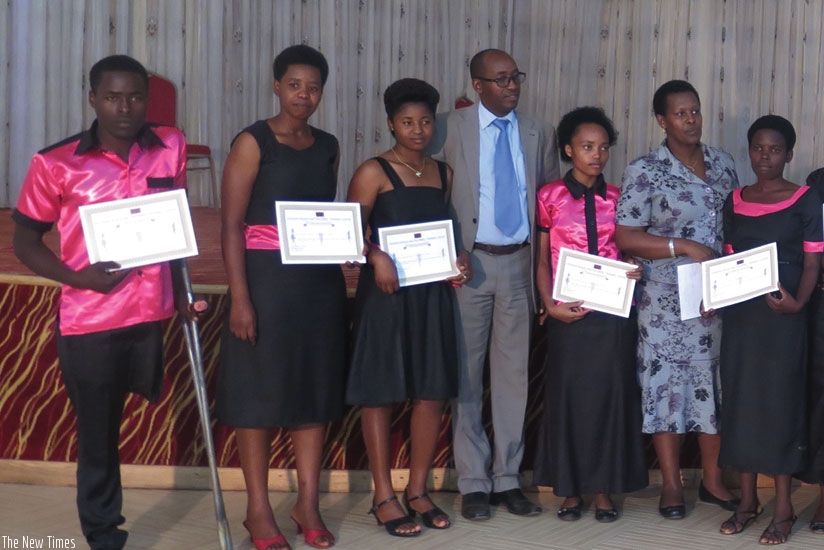 Vice-mayor Tumukunde (second right) and WDA's Livingstone Byandaga pose with some of the graduates. (Mary Ingabire)