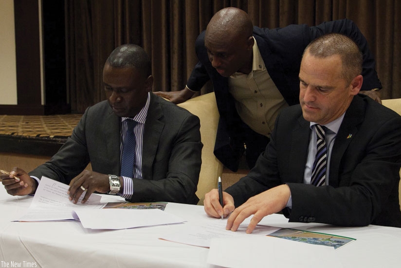 Benjamin Gasamagera (left), the PSF chairman and BVMW chairman Christian Roemlein sign the partnership deal in Kigali last week as PSF acting CEO Gerald Mukubu (centre) looks on. (Peterson Tumwebaze)