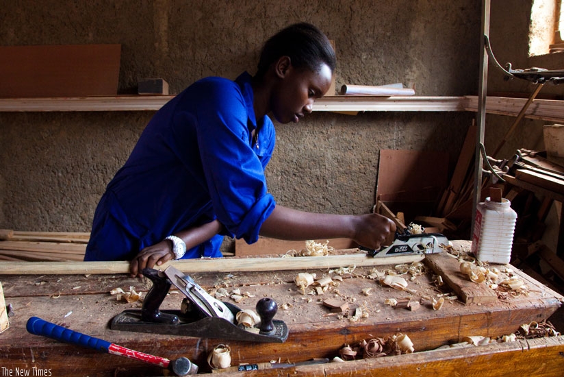 A student at IPRC straightens a warped piece of wood at the IPRC workshop in Kicukiro. (T.Kisambira)