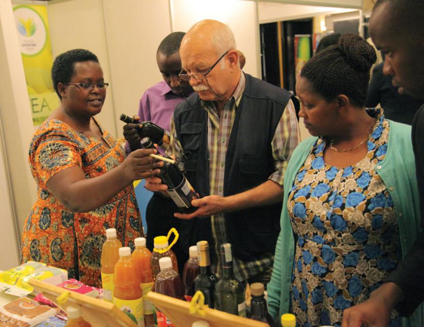 Christine Murebwayire (left) explains how she makes banana wine during a mini-exhibition at the Exportersu2019 Forum last year. (File)