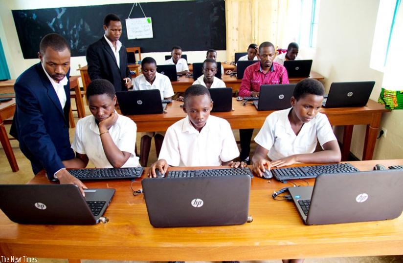 A teacher at GS Rukindo instructs students in a computer class. (Timothy Kisambira)