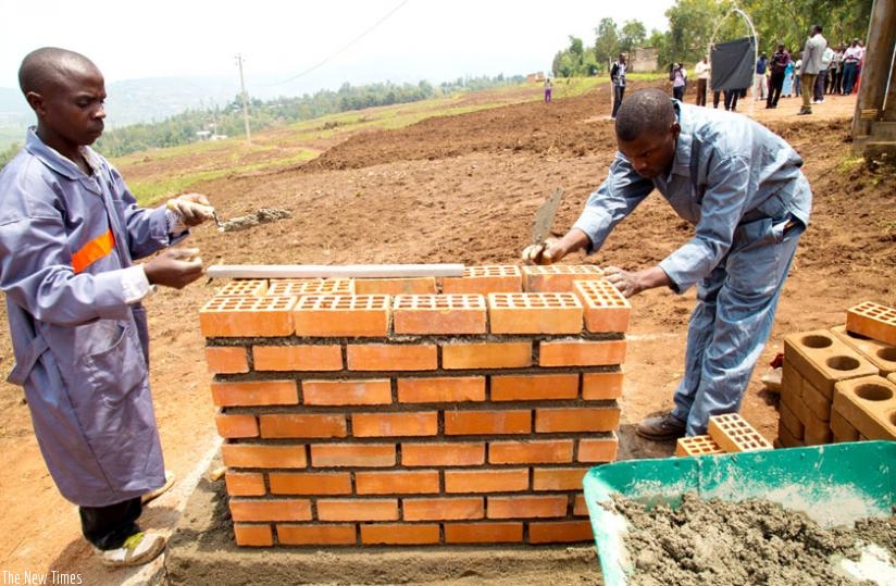 Workers of Horizon construction company build a foundation stone at the site to mark the start of the construction of 7,480 housing units in Batsinda, yesterday. (T. Kisambira)