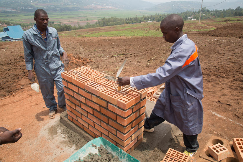 Construction workers build a foundation at the site where the 7,480 houses will be built  in Batsinda. (Timothy Kisambira)
