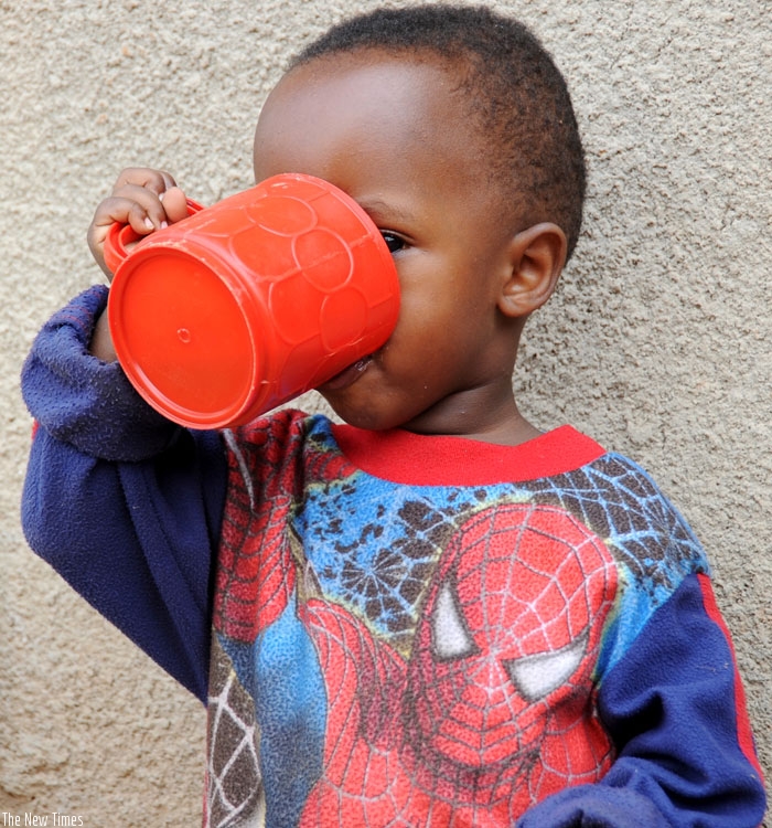 A child enjoys a cup of igikoma. (Timothy Kisambira)