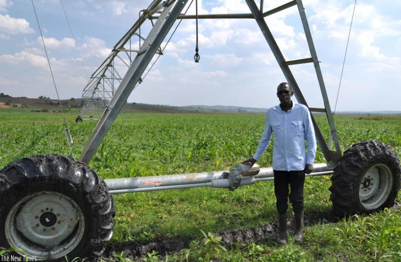A farmer stands next to his irrigation equipment in Nyagatare. Modern farming is key to ending food shortages in EAC. (Peterson Tumwebaze)
