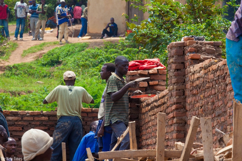 Builders at one of the construction sites in Kinyinya, Gasabo District. (Timothy Kisambira)rn