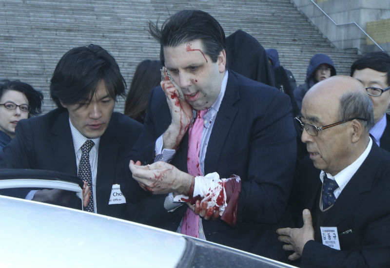 U.S. Ambassador to South Korea Mark Lippert leaves after he was slashed in the face. Agencies