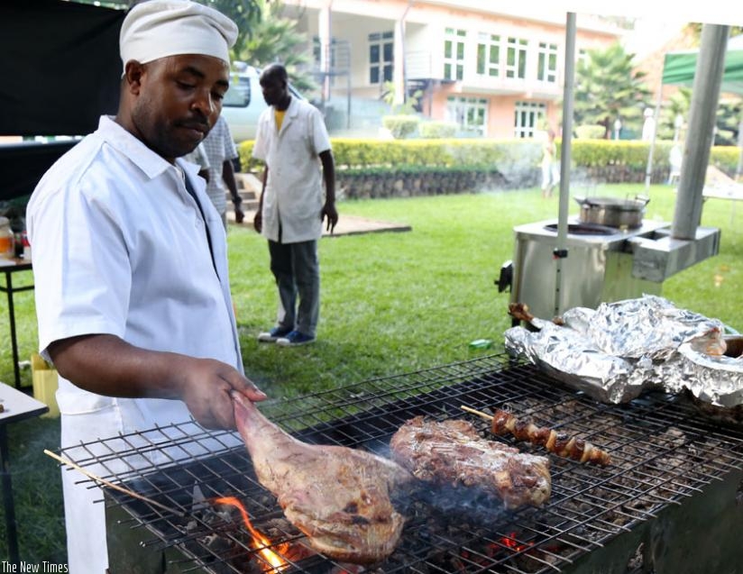 A man roasts goat meat for customers at the party. (John Mbanda)