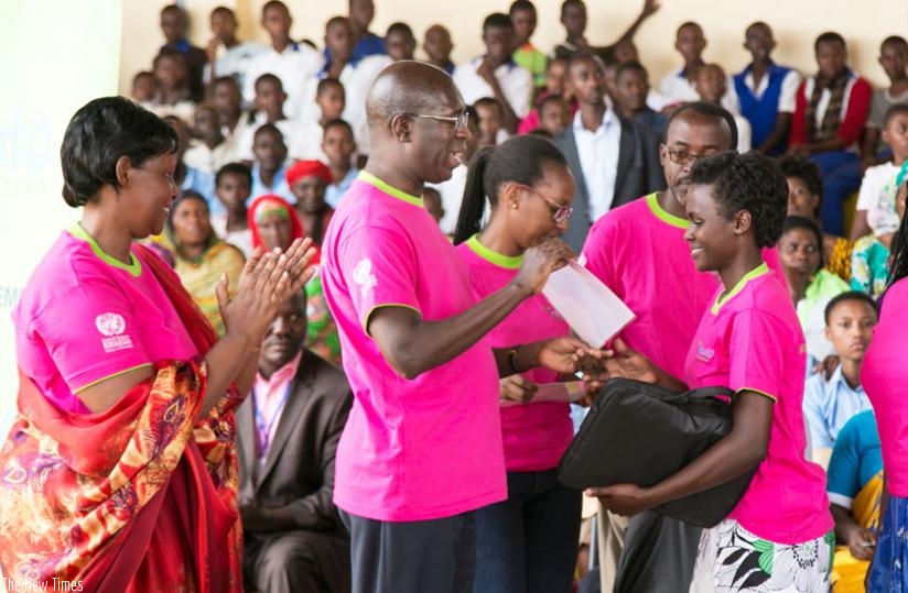 Prime Minister Anastase Murekezi awards best performing girls in last year's national examinations during the national Women's Day celebrations in Ngoma District yesterday. (Courtesy)