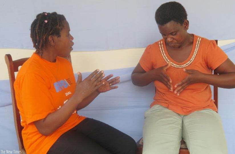 Antoinette Mugabekazi (L) and Bernadette Benemariya (R) engage in a conversation through sign language in Muhanga District over the weekend. (Emmanuel Ntirenganya)
