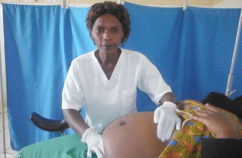 Nurse Esperance Mujawamariya takes care of her patient. (Dennis Agaba)rn