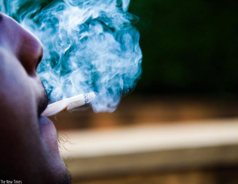 A man smokes in a public place. Smoking is addictive. (Timothy Kisambira)