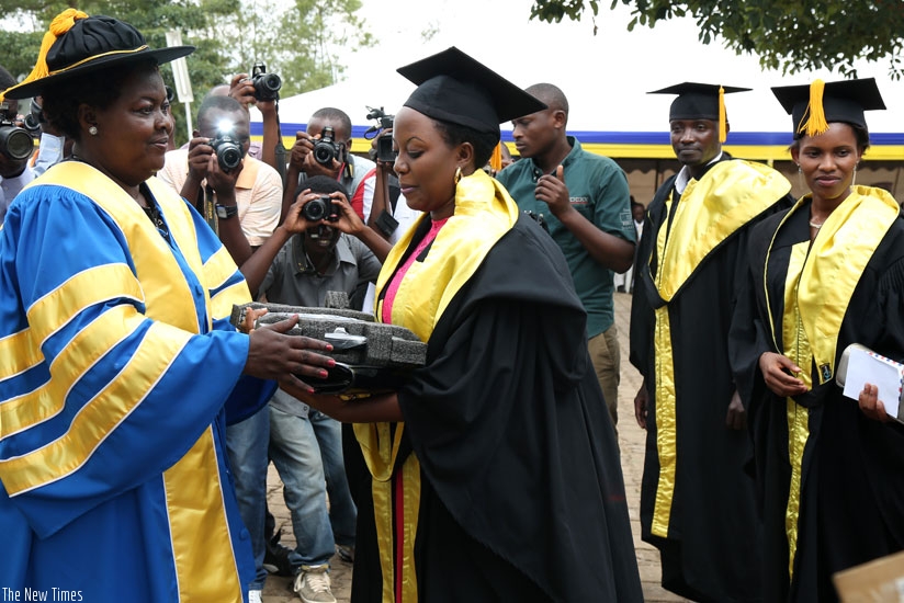 KIM Chancellor Prof Sewe Mutsotso (L) awards the best student Agatha Kwarikunda with a laptop. (John Mbanda)