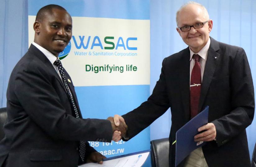 WASAC Managing Director James Sano (L) and Christoph Czekalla from Hamburg Wasser shake hands after signing the MoU. (John Mbanda)