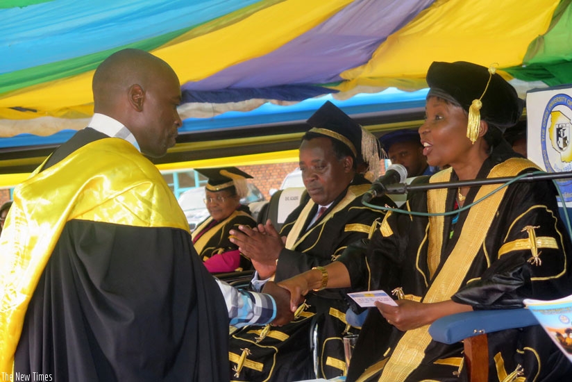 Dr. Asha Rose Migiro (L) confers a degree upon a graduate. (Stephen Rwembeho)