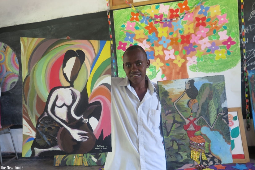 Gilbert Hategikimana shows off his paintings. (All photos by Dennis Agaba)