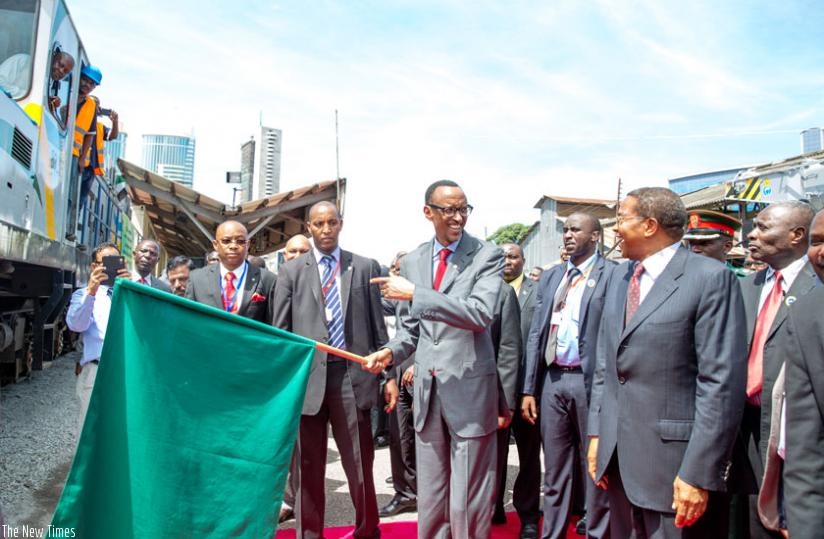 Workers follow the flagging-off ceremony of block trains for the central railway line in Dar es Salaam yesterday. (Courtesy)